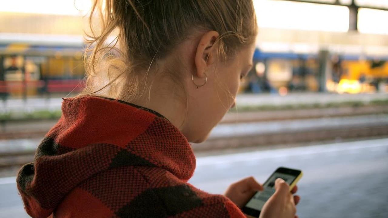 Woman checking her phone at a train station