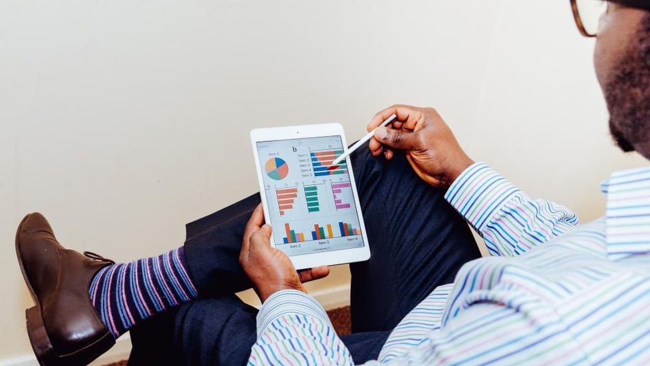 Man holding a tablet showing charts and graphs